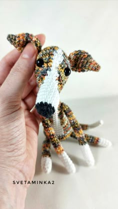 a hand holding a small knitted dog ornament in it's right hand