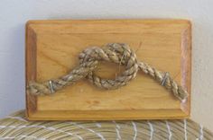 there is a rope on top of a wooden board that is attached to the wall