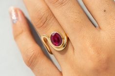 "18k Bezel Set Oval Ruby Ring,Art Deco Engagement Ring,Solid Gold Dee Curved Band,Genuine Ruby,July Birthstone Ring,Anniversary Gift for Her ★ ★ ★  CUSTOM/DUTY-FREE SHIPPING WORLDWIDE, BUYERS DON'T HAVE TO PAY ANY CUSTOM FEES WHILE IMPORTING ★ ★ ★ ★  Details ★ Made to order Material: 14k/18k Gold Color Options: Yellow Gold, White Gold, Rose Gold Stone Details:- Genuine Ruby, Oval Size: 7x9 mm Approx Weight (Ct): 1.71 ★ 100% Natural Diamond and Gemstones ★ Diamond: Round Brilliant cut, G-H Color, SI Clarity ☂ Shipped with Insured Shipping within 4-7 business days. ➦ 100% Free Returns. ➦ Our Jewelry comes with a Lifetime Warranty. (Stone Replacement not included) ✈ We offer free EXPRESS shipping across the world. ★ We can also provide a certificate along with the jewelry. However, it will be Bezel Ruby Ring, Oval Ruby Ring Designs Unique, Oval Birthstone Ring With Polished Finish, Modern Oval Ruby Ring In Gold, Elegant Oval Ruby Ring With Bezel Setting, Modern Oval Gold Ruby Ring, Modern Oval Ruby Ring For Wedding, Gold Oval Birthstone Ring With Tension Setting, Oval Gold Birthstone Ring With Tension Setting