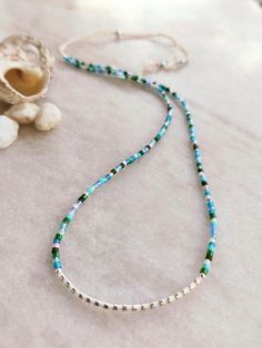 *NEW IN* - Blue Heron Beadwork - This delicately-strung exclusively crafted necklace has a mix of 925 sterling silver 2mm beads and tiny Japanese Miyuki glass beads in satin silk white, Serenity mix and galvanized silver. All beads have different finishes with a mix of blues, pinks and greens. It is finished with a Sterling silver filled sliding clasp to adjust to your size. Wear this alone or layer and stack with other beaded tones for a fun yet elegant look. A great beach holiday essential that goes with everything. Treat yourself or spoil someone special! All items come carefully packaged in pretty sparkly tissue paper and a small jute bag with seaside charm. A white logo'd gift box is available for a small additional cost. Please select from variations. Why not browse our shop and take Silver Single Strand Everyday Beaded Necklace, Blue Minimalist Necklace With Spacer Beads, Handmade Dainty Beaded Necklace In Sterling Silver, Handmade Dainty Sterling Silver Beaded Necklaces, Blue Minimalist Necklaces With Spacer Beads, Minimalist Blue Necklaces With Spacer Beads, Everyday Blue Beaded Necklace With Tiny Beads, Sterling Silver Blue Jewelry With Tiny Beads, Blue Sterling Silver Jewelry With Tiny Beads