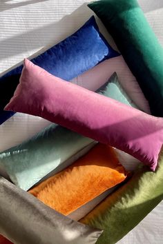 four different colored pillows on top of each other