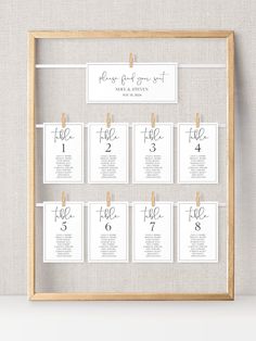 a wooden frame with clothes pins on it and the names of each wedding guest's table