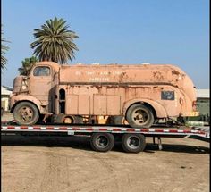 an old truck is being towed by a trailer