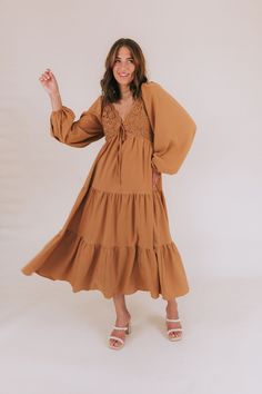 Get ready to fall head over heels for our Falling Faster Dress! This caramel-colored dress features delicate lace detailing and a charming tied bow on the front of the bodice. The smocked panel in the back ensures a comfortable and flattering fit, while the tiered skirt adds a whimsical touch. Complete with long, slightly puffed sleeves and a midi length, this dress also boasts a lace-trimmed neckline for an extra feminine touch. You'll be turning heads and feeling fabulous in this stunning dres Brown Smocked Bodice Dress For Brunch, Brown Smocked Bodice Midi Dress For Brunch, Brown Midi Dress With Smocked Bodice For Brunch, Brown Dresses With Smocked Back For Brunch, Brown Smocked Back Dress For Brunch, Brown Smocked Bodice Dress For Day Out, Brown Dress With Smocked Back For Brunch, Brown Lace Dresses For Spring, Lace Dress With Smocked Bodice For Brunch