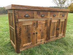 a wooden cabinet sitting on top of a lush green field