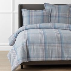 a blue and white plaid comforter set on a bed