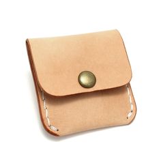 a tan leather case with a button on the front and back side, sitting on a white surface