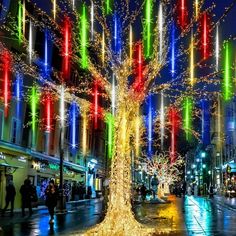 a lighted tree in the middle of a city street