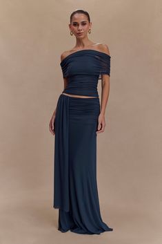 Flowing sophistication. Introducing the ARNA Mesh Maxi Skirt, a perfect blend of elegance and ease. Designed with a flattering mid-rise waist and a timeless A-line silhouette, this skirt drapes beautifully for a graceful look. The discreet side zip ensures a seamless finish, while the mini-length lining provides coverage beneath the lightweight mesh overlay, creating a soft, layered effect. Perfect for day or night, this skirt pairs effortlessly with the Arna Off Shoulder Mesh Crop Top. Mesh Maxi Skirt, Skirt Draping, Mesh Crop Top, Mesh Overlay, Asymmetrical Skirt, Black Maxi Dress, Summer Wardrobe, Midnight Blue, Side Zip