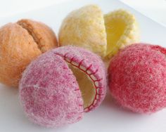 four different colored felt balls on a white surface