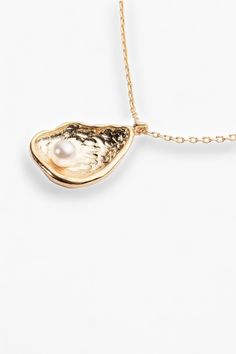 Prepare to turn heads and drop jaws with our Gold Dipped Oyster Necklace! This elegant masterpiece boasts a stunning oyster shell and delicate pearl pendant, all fabulously dipped in 18K gold for that dazzling touch of opulence. Whether you’re glamming up for date night or simply adding a sprinkle of sparkle to your daytime ensemble, this chic piece is your new go-to. At a perfect 16” length, it sits gracefully on your neckline, adding that unique twist you crave for every outfit. Wear it, flaun Oyster Shell Necklace, Oyster Necklace, Outfit Elegant, Jewelry Aesthetic, Graphic Tee Dress, Mink Pink, Gold Dipped, Sock Gifts, Oyster Shell