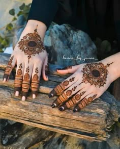 two hands with henna tattoos on them