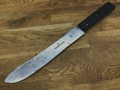 a large knife sitting on top of a wooden table