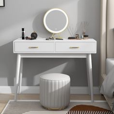 a white dressing table with a round mirror and stool in the corner next to it