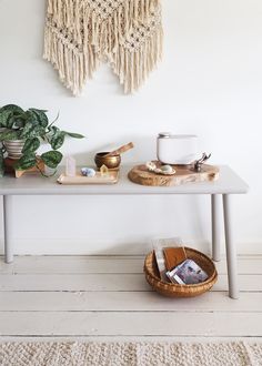 a table with some items on it and a potted plant in the corner next to it