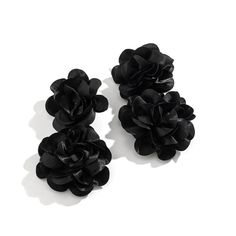 three black flowers are sitting on a white surface