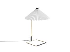 a lamp that is on top of a white surface with a black cord attached to it