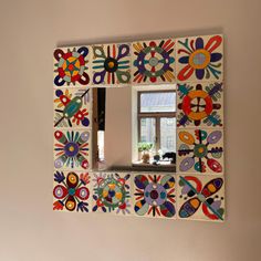 a colorful mirror hanging on the side of a wall