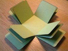 several pieces of folded paper sitting on top of a wooden table