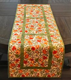 Handmade table runner featuring fall pumpkins and green leaves on a cream background, accented with a green border and binding. This runner would be the perfect addition to your dining table, hutch or entry area for the fall and Thanksgiving months. The backing fabric is the same fall pumpkin print as was used on the front. Size is 15 1/2" X 49 1/2" Runner has been professionally quilted in an all over swirl pattern. The double fold binding has been machine sewn to the front and hand sewn to the back for a professional appearance. Care Instructions: The easiest way to clean your runner is to just vacuum it. If you want a deeper cleaning, wash gently in cold water; tumble dry on low (or air dry to prevent shrinkage). Iron as necessary. This runner was machine pieced and quilted by me in my Fall Table Runner Patterns, Christmas Tree Quilt Block, Tree Quilt Block, Pinwheel Quilt Block, Pumpkin Table Runner, Entry Area, Christmas Tree Quilt, Fall Table Runners, Handmade Table Runner