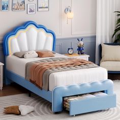 a blue and white bed sitting in a bedroom next to a window with pictures on the wall