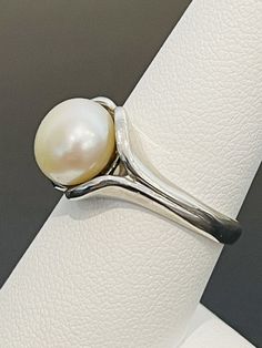 This is a classic and timeless look. Pearls have become en vogue again and this is a ring that would appeal to most women. Great for work or everyday. This ring is made in sterling silver and is a size 8. This pearl is 10 mm. Classic Adjustable Ring With Open Band, Silver Timeless Stackable Rings For Formal Occasions, Timeless Silver Stackable Rings For Formal Occasions, Classic White Dome Ring For Wedding, Elegant Silver Stackable Rings With Polished Finish, Classic Sterling Silver Ring, Silver Stackable Rings Timeless Style For Formal, Timeless Silver Pearl Ring With Polished Finish, Timeless Silver Sterling Silver Pearl Ring