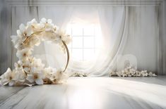 a white flower wreath sitting on top of a wooden floor in front of a window