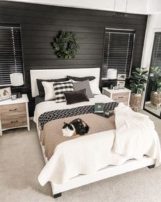 a black and white bedroom with a cat on the bed