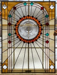 a large stained glass window with an orange and green circle on it's center