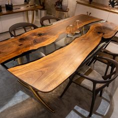 a table made out of wood and glass with chairs around it in a showroom