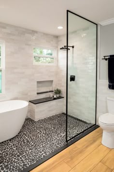 a white bath tub sitting next to a toilet in a bathroom