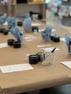 a table with several cups and napkins sitting on it's sides, all covered in blue origami