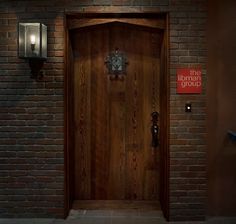 a wooden door in front of a brick wall with a sign that says the highland group