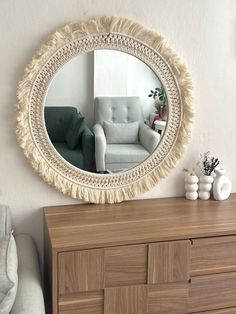 a mirror that is on the wall above a dresser