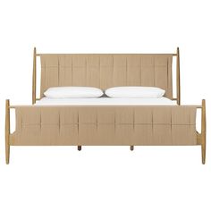 a bed with two pillows on top of it and a wooden frame around the headboard