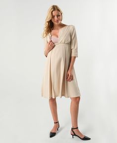 Where power meets femininity, the Sarah is the go-to confidence booster in your maternity wardrobe. The stunning pleated skirt ends in an empire waistline perfect for all different kinds of tummy days. Bonus, the skirt hides two HUGE pockets - a mama's best friend. The Sarah's dramatic cuffs, lightly padded shoulders, and adjustable v-neckline with teardrop zip (perfect for nursing) make this an unforgettable statement piece. Its easy, flattering silhouette will make it one of the most effortles Nursing-friendly V-neck Maternity Dress, Fitted Nursing-friendly Maternity Dress For Summer, Nursing-friendly Fitted Maternity V-neck Dress, Maternity Fitted Nursing-friendly Dress, Daywear Nursing-friendly Maternity Dress, Breastfeeding Dress, Feminine Skirt, Maternity Nursing Dress, Workwear Essentials