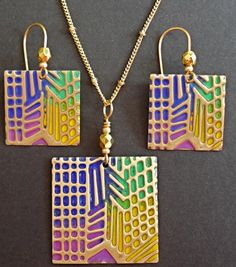 An Art-Deco pattern is embossed on solid brass and painted in rainbow colors; then the brass is sanded to reveal the metal beneath and polished to a shine. The earrings are attached to gold plated or solid brass hook wires, and the pendant comes with a chain or cord and lobster claw clasp. Round set: solid brass earring wires and black rattail pendant cord. Square set: gold plated earring wires and gold tone chain. Artistic Multicolor Copper Jewelry, Unique Multicolor Brass Jewelry, Unique Multicolor Patina Jewelry, Unique Multicolor Jewelry With Patina, Hand Painted Gold Brass Earrings, Artsy Gold Copper Jewelry, Etched Gold Copper Jewelry, Etched Copper Gold Jewelry, Hand Painted Gold Metal Jewelry