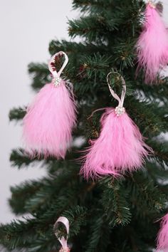 pink ornaments hanging from the top of a christmas tree