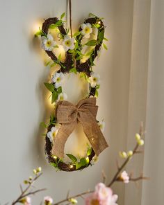 a wreath with flowers and lights hanging on the wall