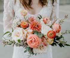 a woman holding a bouquet of flowers in her hands and wearing a white dress with long sleeves