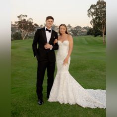 a man and woman in formal wear posing for a photo on the golf course at sunset