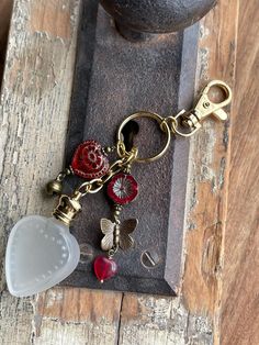 a keychain with some charms attached to it sitting on a table next to a pot