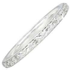 a white gold wedding band with intricate engraving