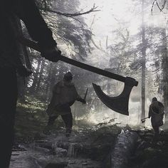 two people walking through the woods with axes