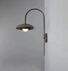 a wall light that is on the side of a wall with a lamp attached to it