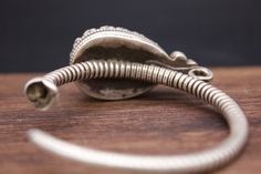 Large Silver ear ornaments. The hoops are made of pearled wire and the bezel is decorated with a large blue Turquoise. Excellent workmanship with a great patina for its age. This is a rare Museum piece. This particular design is worn in pairs by women and single by men from Kham in East Tibet. These pieces might have been handed down to generations. *wear and tear as per age, intact. Combined Weight: 42 grams Ring Size: 48mm Origin: Early 19th c Tibet Handmade Vintage Spiral Jewelry, Traditional Engraved Hoop Earrings, Traditional Adjustable Hoop Jewelry, Traditional Spiral Jewelry For Gifts, Traditional Antique Finish Bangle Jewelry, Traditional Engraved Round Hoop Earrings, Traditional Engraved Hoop Earrings Gift, Traditional Handmade Spiral Jewelry, Traditional Adjustable Spiral Jewelry