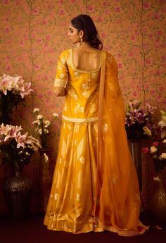 Step into refined elegance with the gold yellow appliqué silk brocade choli kurta, beautifully paired with a multi-panel brocade lehenga. This stunning ensemble showcases intricate appliqué detailing that enhances the luxurious brocade fabric, while the flowing lehenga offers a beautiful silhouette. Complemented by an embroidered dupatta, this outfit is perfect for festive occasions, blending traditional charm with modern sophistication. Yellow Choli, Brocade Lehenga, Beautiful Silhouette, Embroidered Dupatta, Casual Tunics, Silk Brocade, Brocade Fabric, Silk Organza, Indian Ethnic Wear