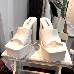 White Modern 4-inch Heels For Spring, White Square Toe Heels With 4-inch Heel, Modern White Mules With Sculpted Heel, Chic Platform Heels With Square Toe, White Platform Heels With Square Toe, White Platform Heels In Trendy Style, White Pointed Toe Mules With Padded Heel, White Square Toe Mules With Branded Heel, White Square Toe Platform Heels