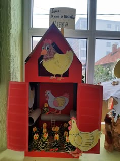 there is a red house with chickens in the front and on the outside, next to a window