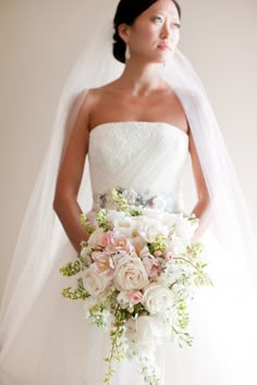 a woman in a wedding dress holding a bouquet